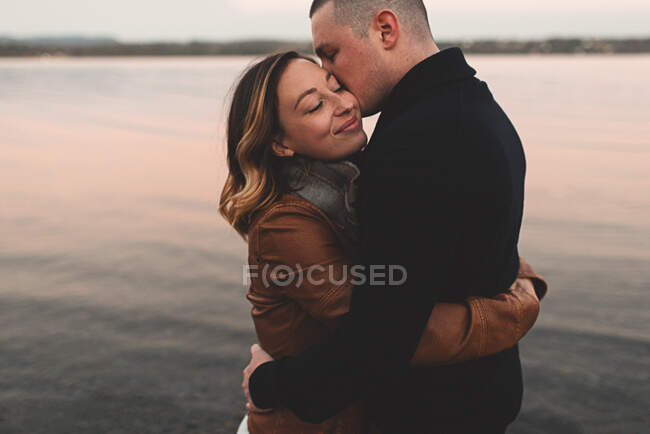 Couple hugging and kissing by sea, Ottawa, Ontario — Stock Photo