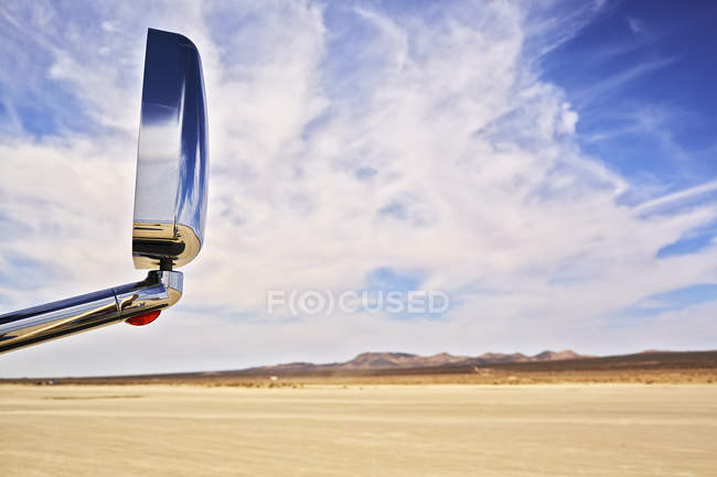 Blick auf Auto-Außenspiegel mit trockener Landschaft und wolkenlosem blauem Himmel — Stockfoto