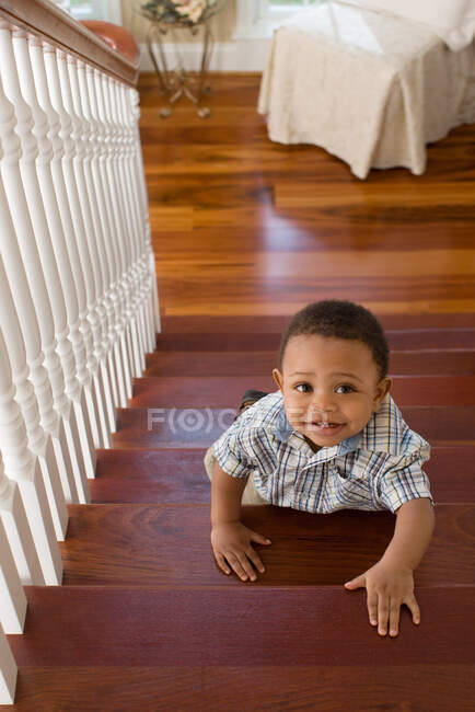 Un chico subiendo escaleras - foto de stock