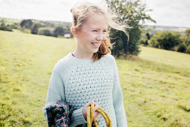 Pre-adolescent girl in countryside field smiling — Stock Photo