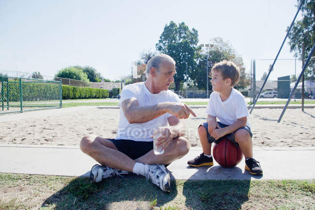 Чоловік дає онуку баскетбольний перець говорити — стокове фото