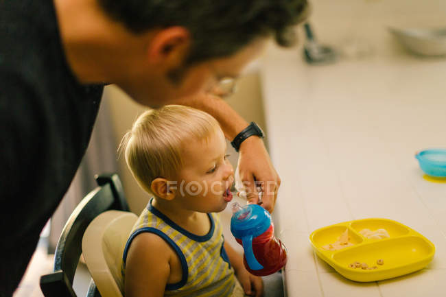 Pai ajudando filho jovem na hora da refeição — Fotografia de Stock