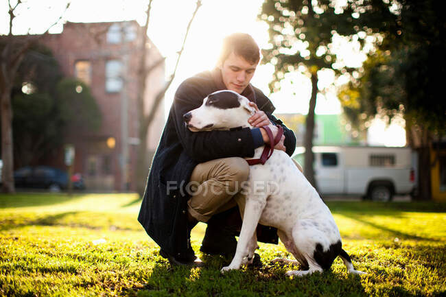 Uomo che abbraccia cane nel parco — Foto stock