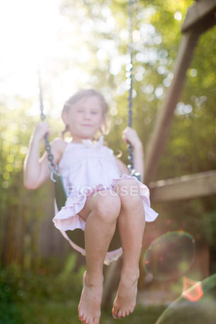 Портрет девушки, качающейся на качелях в саду — стоковое фото