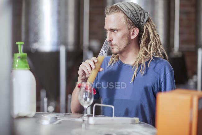 Cape Town, South Africa, young male testing beer from glass in brewery — Stock Photo