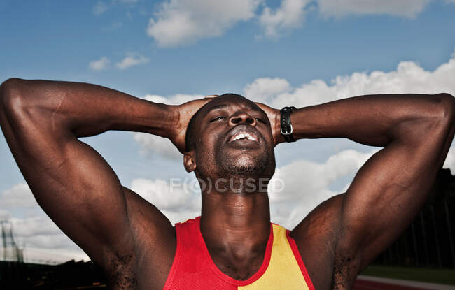 Male athlete holding head outdoors — Stock Photo