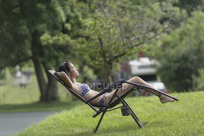 Young girl relaxing and sunbathing in yard — Stock Photo