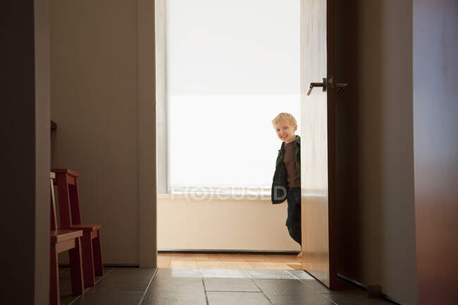 Хлопчик шукає круглий дверний отвір — стокове фото