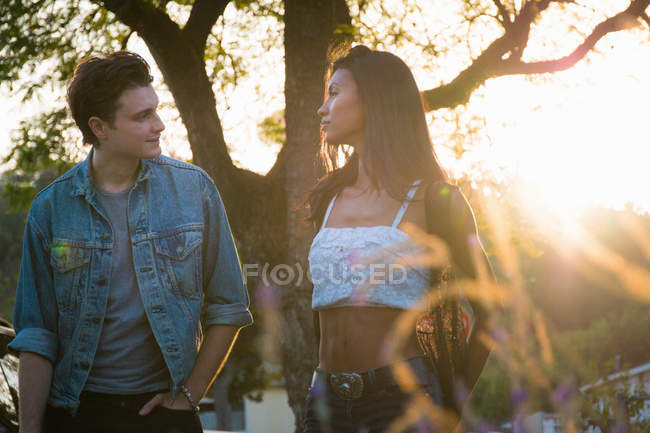 Young couple walking outdoors at sunset — Stock Photo