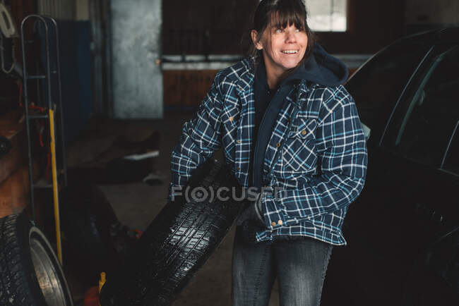Жінка, що носить шини в майстерні — стокове фото
