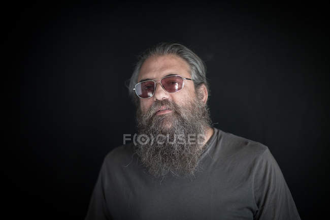 Portrait of mature man with beard, against black background — Stock Photo