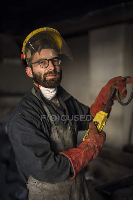 Cape Town, South Africa, worker in fire suit working at bronze foundry — Stock Photo