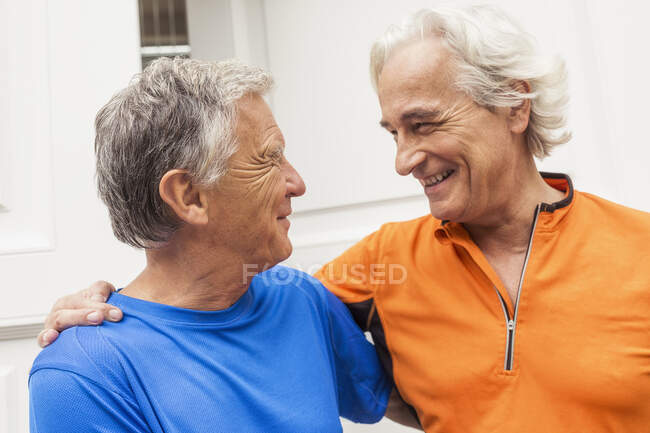 Two happy senior male runners at front door — Stock Photo