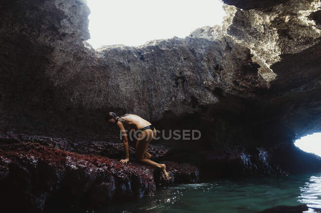 Молода жінка, яка піднімається на скелі, печери Русалки, Оаху, Гаваї, США — стокове фото