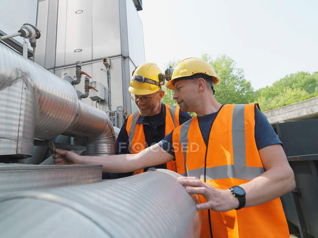 Workers examining machinery on site — Stock Photo