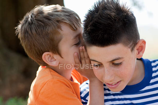 Boy whispering to firiend — Stock Photo