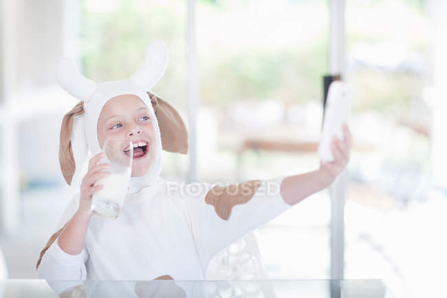 Fille prenant une photo d'elle-même boire un verre de lait — Photo de stock