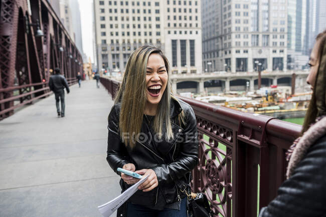 Two friends, standing on bridge, laughing — Stock Photo