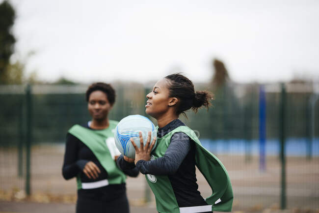 Jovem jogador de netball feminino adulto em jogo na quadra de netball — Fotografia de Stock