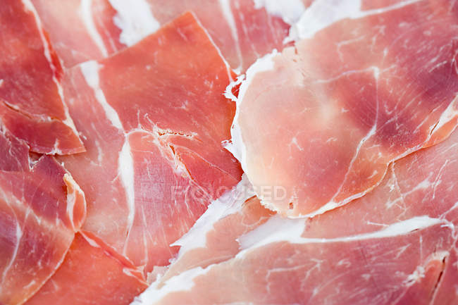 Vista close-up de delicioso presunto de parma fatiado, fundo de comida mediterrânea — Fotografia de Stock