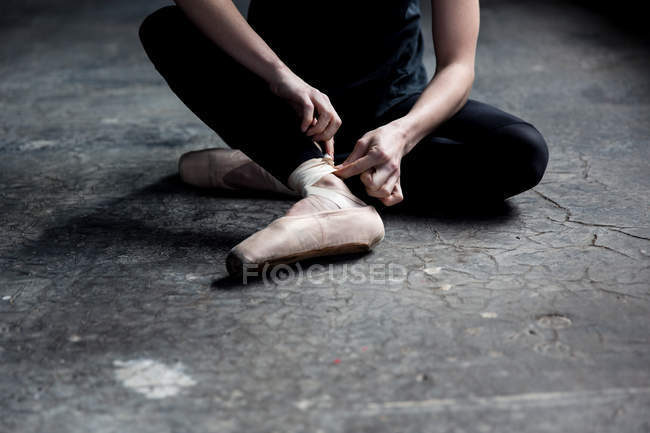 Dancer wearing ballet shoe in studio — Stock Photo