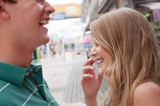 Adolescente casal rindo do parque de diversões — Fotografia de Stock