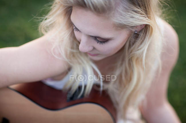 Frau spielt Gitarre im Gras — Stockfoto