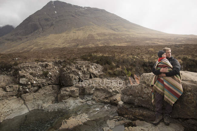 Padre sosteniendo hijo, Piscinas de hadas, Isla de Skye, Hébridas, Escocia - foto de stock
