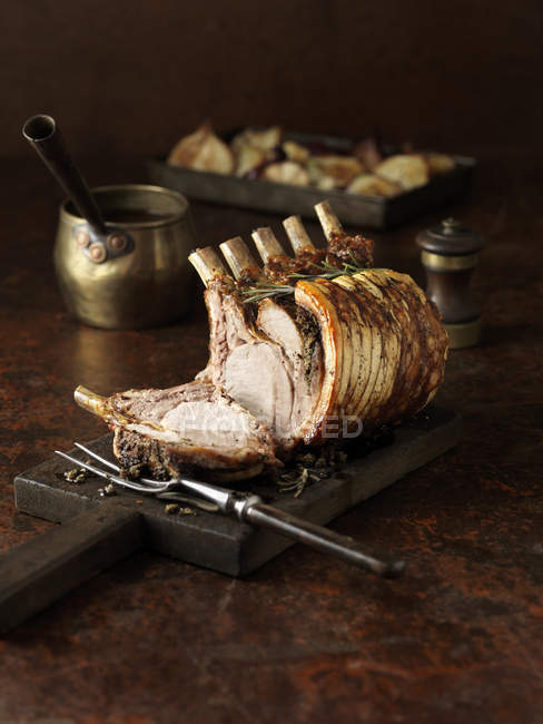Carved rack of pork on kitchen table — Stock Photo