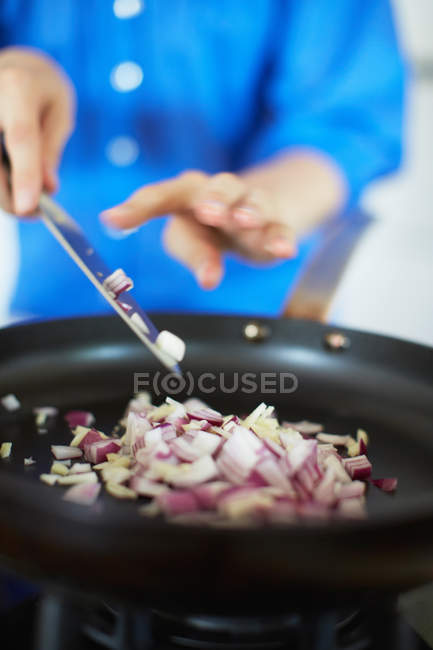 Primo piano visione parziale della donna frittura cipolla, messa a fuoco selettiva — Foto stock