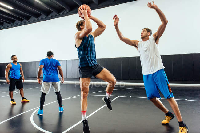 Männliche Basketballer springen mit Ball im Basketball Spiel — Stockfoto