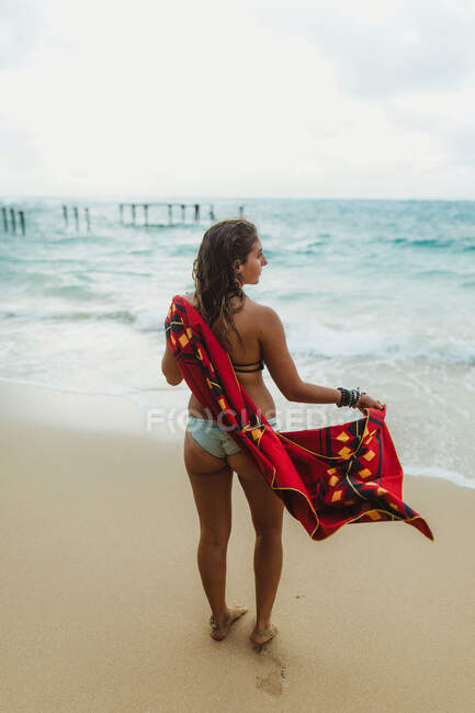 Vista trasera de la mujer en la playa secándose con toalla, Oahu, Hawaii, EE.UU. - foto de stock
