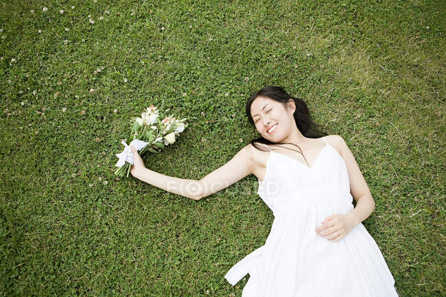 Noiva deitada na grama — Fotografia de Stock