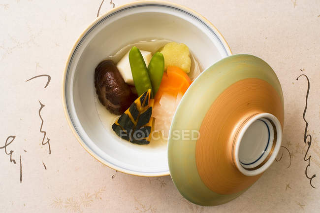 Schüssel und Deckel mit frischem gedünstetem Gemüse — Stockfoto