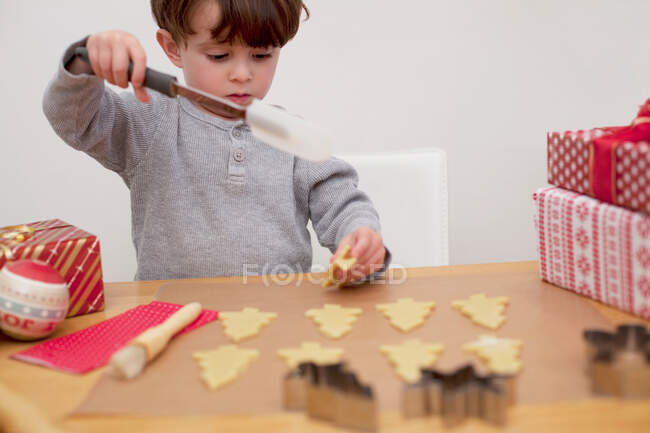 Boy baking Christmas biscuits, holding spatula — Stock Photo