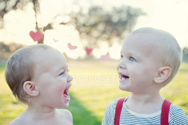 Hermano y hermana riendo al aire libre - foto de stock