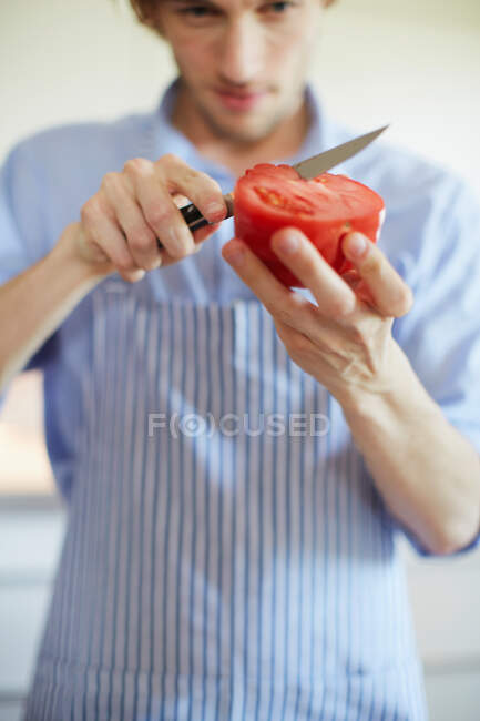 Gros plan de l'homme tranchant la tomate — Photo de stock