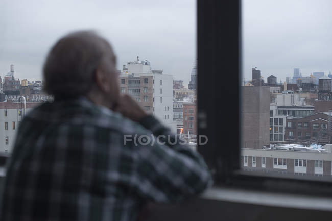 Mann schaut aus dem Fenster, manhattan, New York, Vereinigte Staaten — Stockfoto
