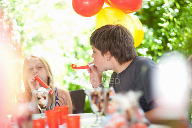 Crianças soprando barulhentos na festa — Fotografia de Stock