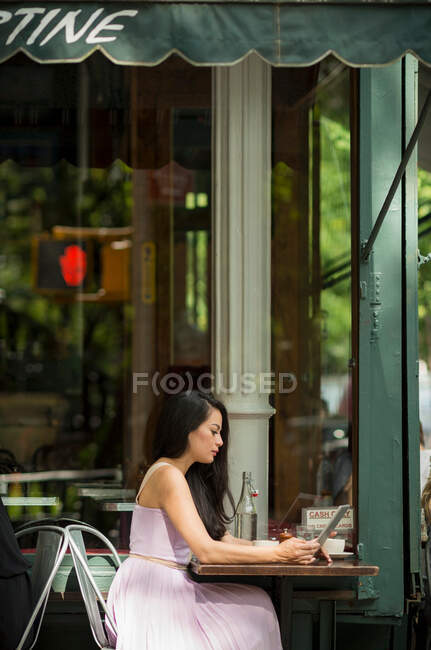 Mid adult women using digital tablet in pavement cafe — Stock Photo