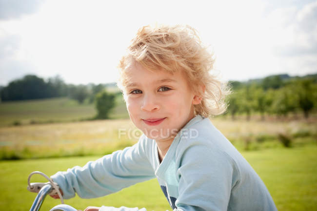 Мальчик на велосипеде в деревне — стоковое фото