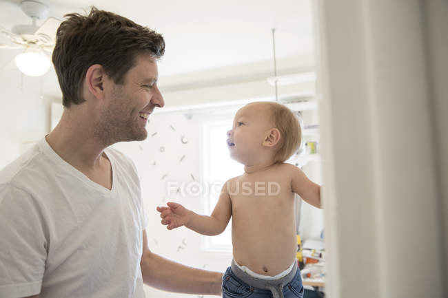 Отец и маленький сын, лицом к лицу, улыбаясь — стоковое фото
