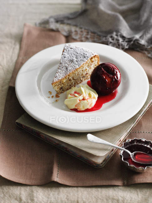 Assiette de gâteau aux noisettes avec crème et fruits glacés — Photo de stock