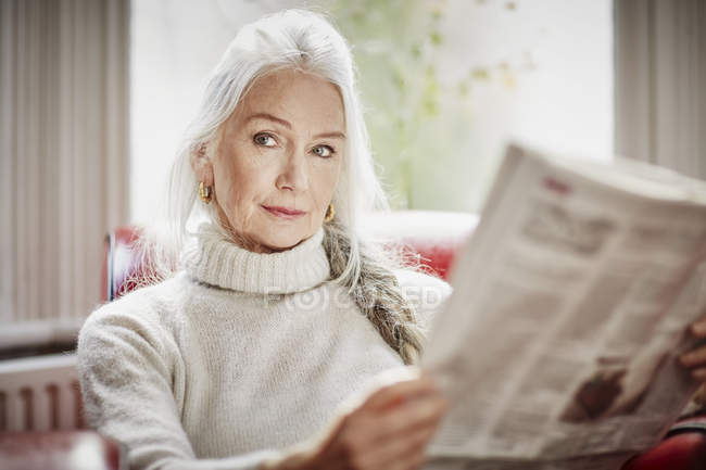 Mujer mayor leyendo periódico - foto de stock