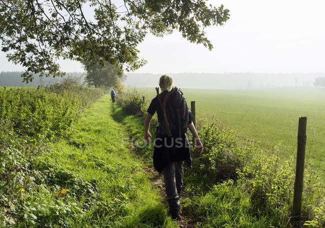 Rückansicht des jugendlichen jungen wanderns entlang des antiken römischen weges, beaufort, echternach, luxembourg — Stockfoto