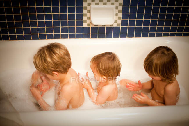 Tres chicos tomando un baño juntos - foto de stock