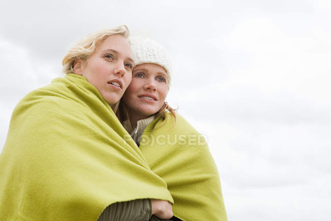 Mulheres compartilhando um cobertor — Fotografia de Stock