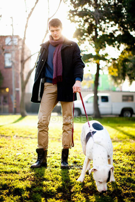 Чоловік гуляє собакою в парку — стокове фото