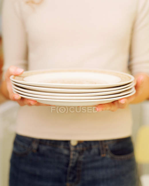Abgeschnittenes Bild einer Frau mit weißen Tellern — Stockfoto