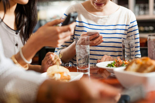 Menschen im Restaurant schreiben SMS — Stockfoto